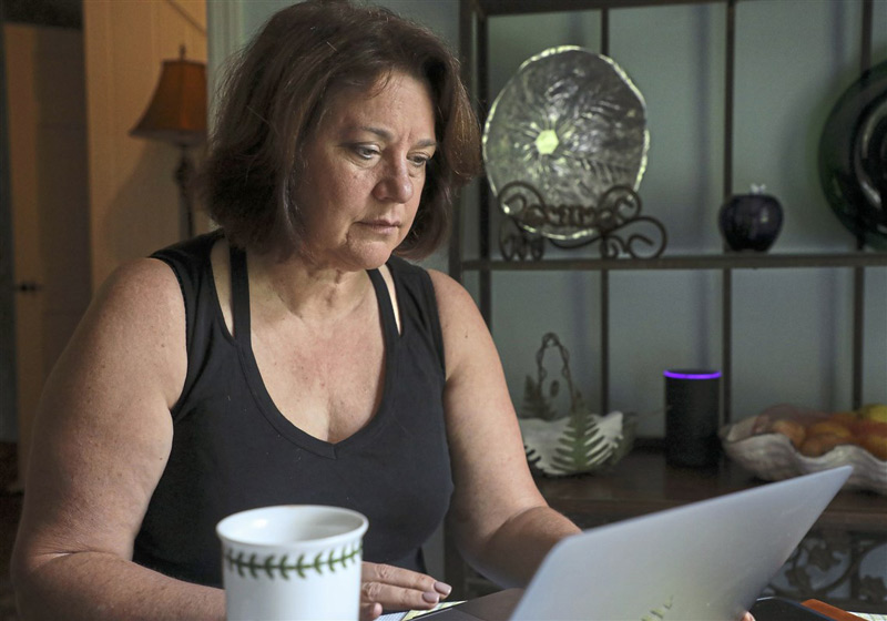 Colleen Cenk sits at her dining room table to review paperwork